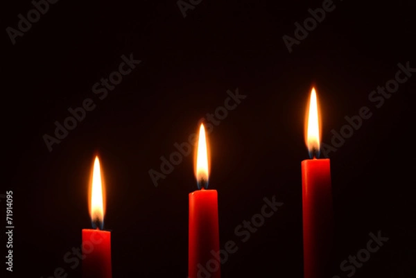 Obraz Three red candles on a black background