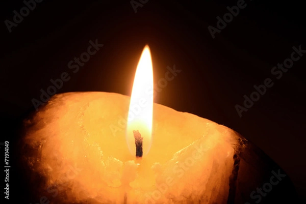 Obraz Burning candle on a black background