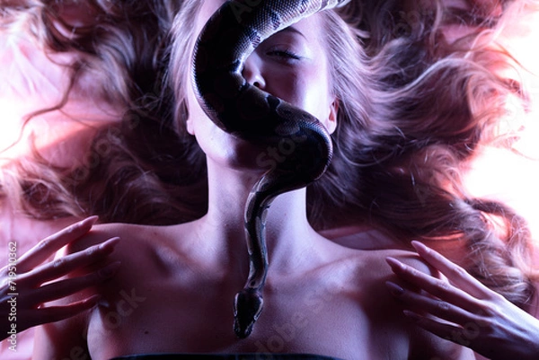 Obraz Snake python shooting on blond young woman with light effekts