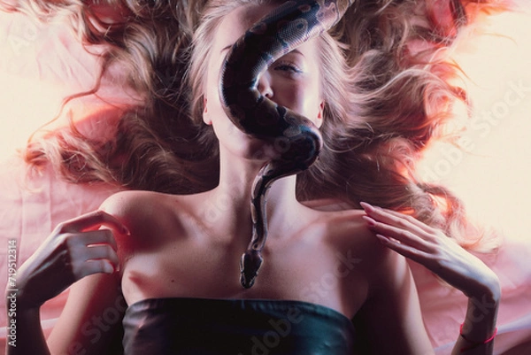 Obraz Snake python shooting on blond young woman with light effekts