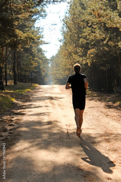 Obraz Barefoot runner running through autumn forest