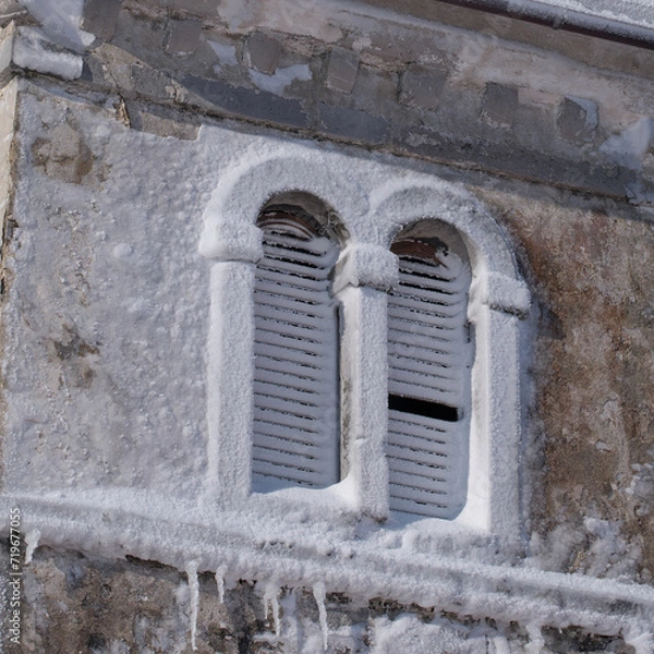 Obraz Snow covered church tower windows due to the blizzard during the night