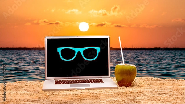 Fototapeta Laptop on the beach wearing sanglass and drinking coconuts water