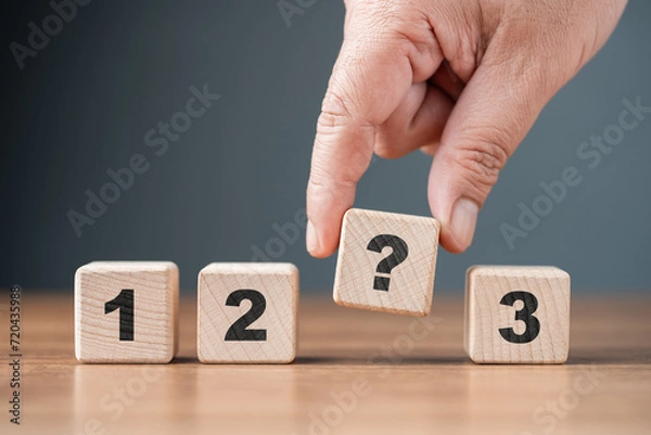 Fototapeta Hand pick a question wood cube in a row of one, two, and three, choosing between three, or multiple options, question for selection