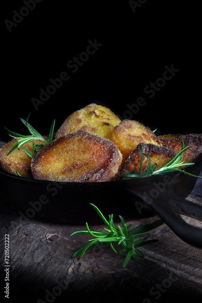 Fototapeta Rustic Roast Potatoes with Rosemary Garnish