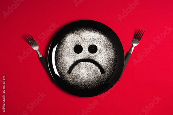 Obraz Sad face, concept made with plate and flour, red background, star shaped eyes, black plate, happy mood, facial expressions, forks in the shape of arms with different positions