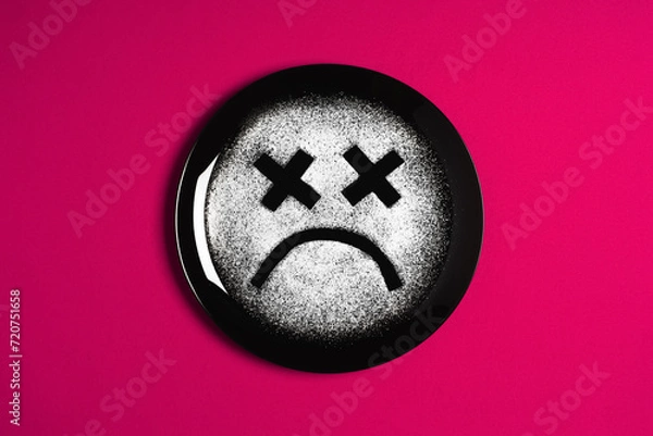 Obraz Sad face, concept made with plate and flour, red background, x-shaped eyes, black plate, happy mood, facial expressions