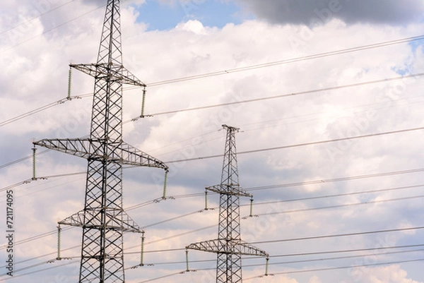 Fototapeta High voltage towers with sky background. Power line support with wires for electricity transmission. High voltage grid tower with wire cable at distribution station. Energy industry, energy saving