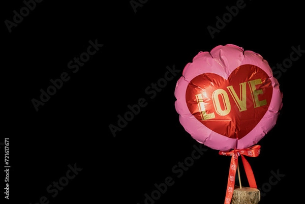 Fototapeta pink balloon with heart shape and test "Love" with black background and space for text.