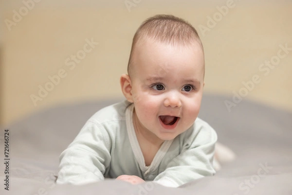 Obraz Baby boy on a bed smiling and happy. Close up portrait