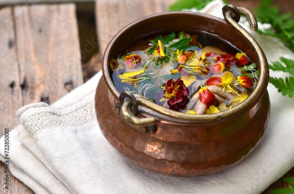 Fototapeta Dyeing of fabric with natural dyes, fabric in a copper vat with plants, marigolds, linen, environmental friendliness.