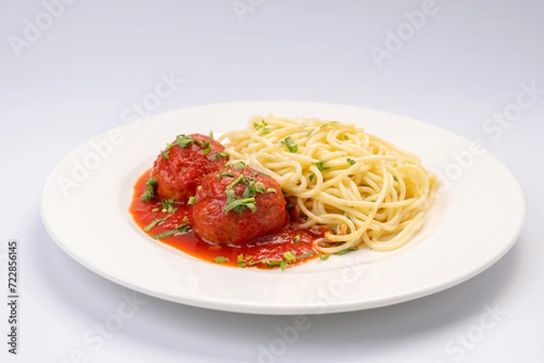 Fototapeta Business lunch. Meat balls in tomato sauce with spaghetti on a white background
