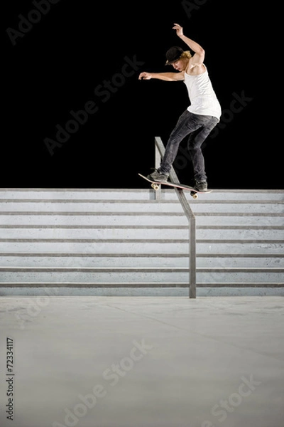 Fototapeta boy doing skateboard trick on rail