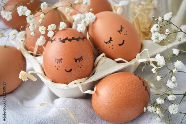 Obraz Happy Easter! Easter eggs on a rustic table in a cardboard box with hay.