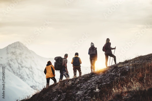 Obraz Group of mixed age hikers are standing on mountain slope and looking at sunset