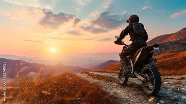 Fototapeta A male expert motorcyclist in complete gear riding a dirt bike on a mountain road during sunset, with a 3D rendered background, representing the thrill of motor racing.