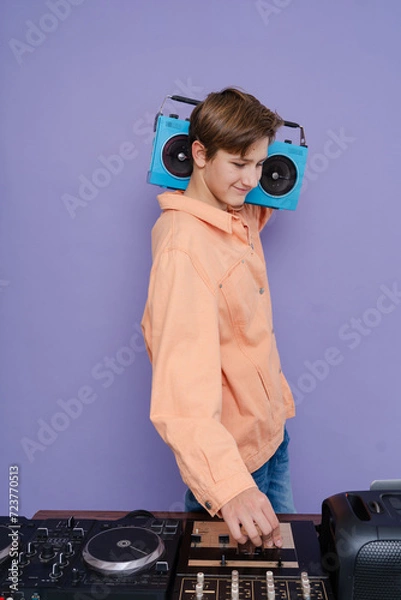 Fototapeta Charming boy hold boom box on his shoulder want listen  music isolated over bright color background