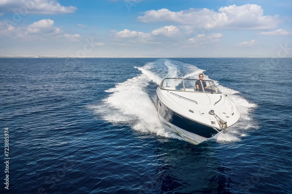 Fototapeta Aerial front view of a sports motor boat cruising with high speed over the blue sea