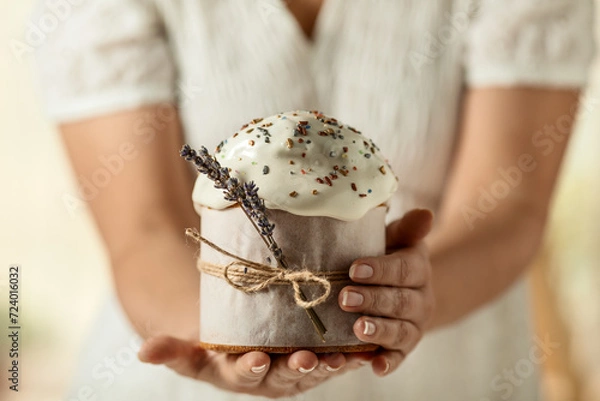 Fototapeta traditional Orthodox Easter cake, in women's hands, close-up on a light background. happy Easter