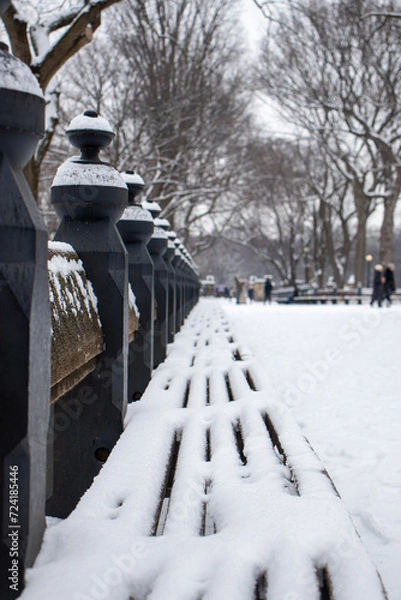 Fototapeta snow covered bench in the park