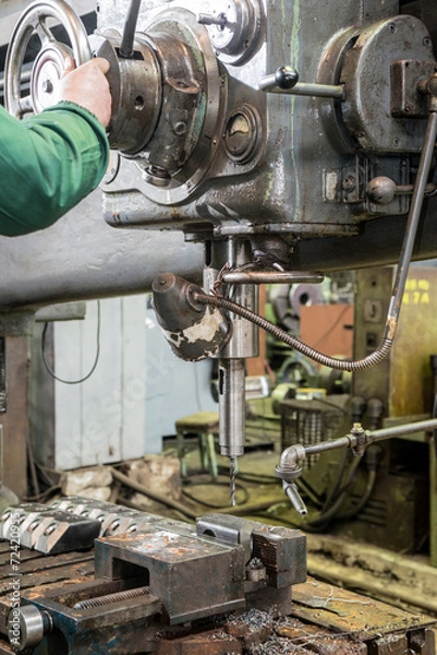 Fototapeta machinist working on industrial drilling machine in workshop