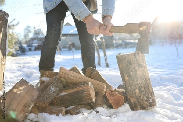 Obraz Man chopping wood with axe outdoors on winter day, closeup