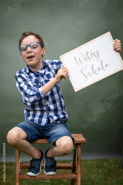 Fototapeta witaj szkoło, chłopiec z tabliczka 1 września zaczyna szkołę 