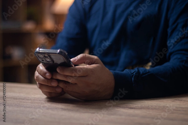 Obraz Men's hands on the table use mobile phones, technology, communications, the Internet.