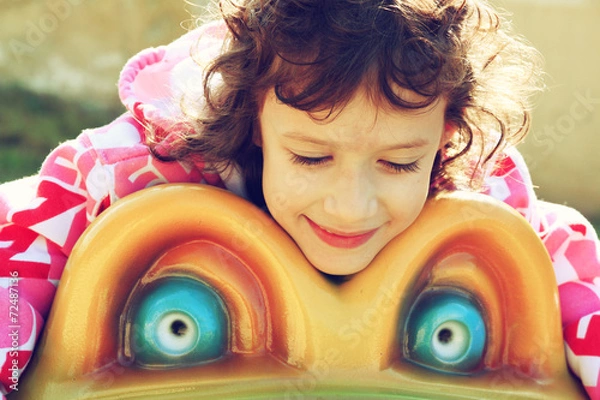 Fototapeta cute little girl playing and having fun on the playground, in an