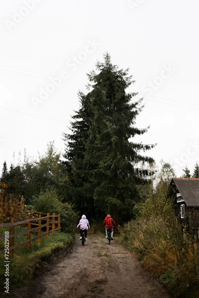Fototapeta Biker couple riding mountain bicycle in the forest at countryside
