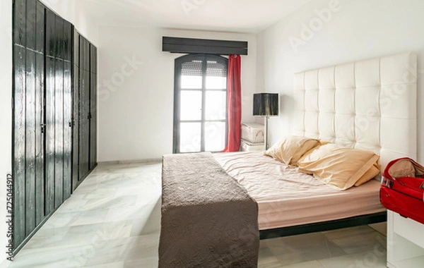 Obraz a simple guest bedroom with original wooden wardrobes in mediterranean apartment 