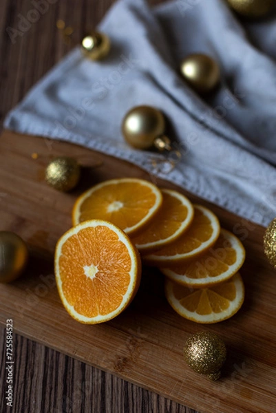 Fototapeta New Year's layout of oranges, board, napkins, garlands and balloons on the kitchen table.Preparations for the holiday.Preparing for the celebration of Christmas.Cooking dried oranges