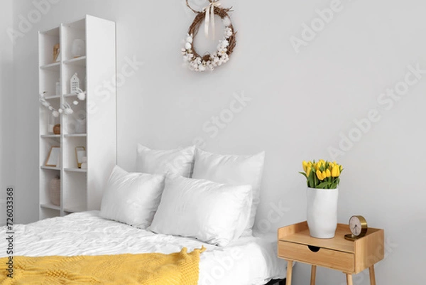 Fototapeta Interior of light bedroom with Easter wreath and shelf unit