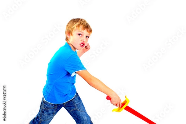 Fototapeta Young boy in studio playing with sword on white background