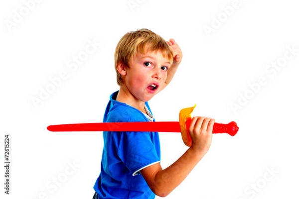 Fototapeta Young boy in studio playing with sword on white background