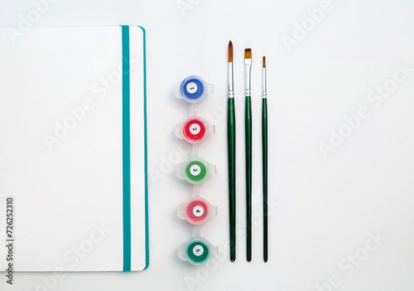 Obraz Notepad with paints and brush