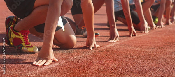 Fototapeta Cropped image of a sprinter getting ready to start at the stadium