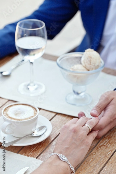 Fototapeta woman's and man's hands holding in cafe with ice-cream and coffe