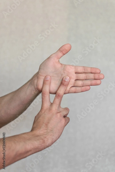 Fototapeta a young man shows gestures of the deaf and dumb. the language of people with disabilities. sign language