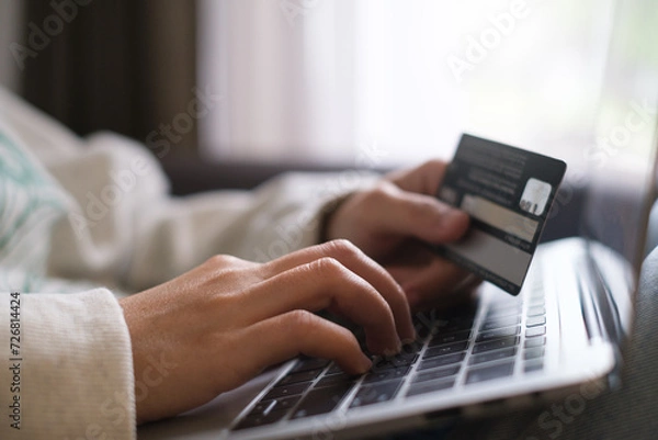 Fototapeta Hands holding credit debit card and using keyboard on laptop at home. Online shopping ,network banking account payment money for buy or purchase and sale concept.