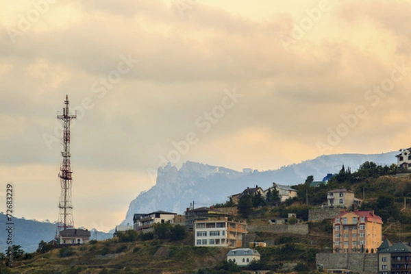 Fototapeta Radio tower and a building in the mountains at sunset