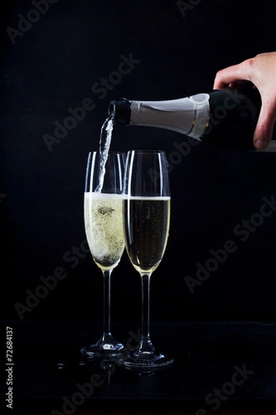 Obraz Champagne pouring in two glasses from a bottle