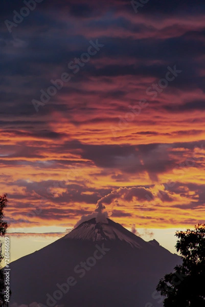 Obraz Volcano at sunset with orange clouds 