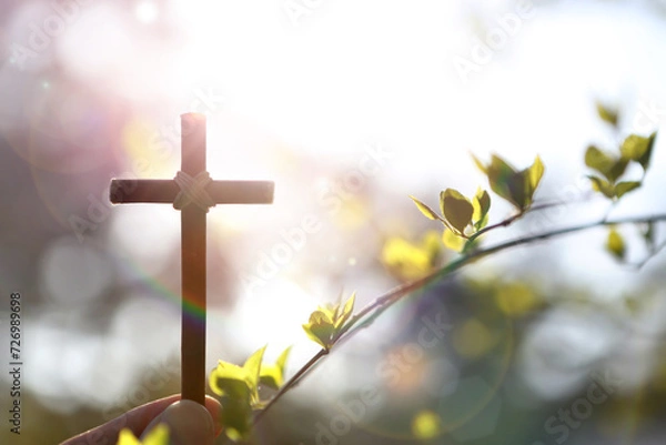 Obraz Background with yellow forsythia flowers and buds and the holy cross of Jesus Christ in hand on a warm spring day with strong sunlight
