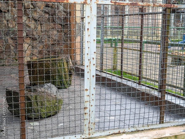 Fototapeta Outdoor fence at the zoo. Empty cages in the zoo. Winter at the zoo. The animals hid. Empty animal enclosure.