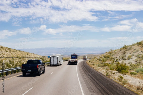 Fototapeta Beautiful blue sky with fluffy clouds over the highway on a spring day. Arizona sign. Scenic road in Arizona, USA on a sunny summer day. Arizona, USA - 17 April 2020