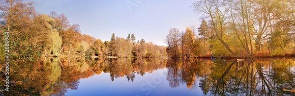 Fototapeta panorama of autumn trees at a glassy lake