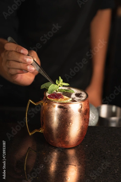 Obraz barman adding mint to a moscow mule