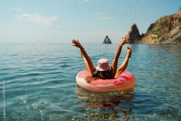 Obraz Summer vacation woman in hat floats on an inflatable donut mattress. Happy woman relaxing and enjoying family summer travel holidays travel on the sea.