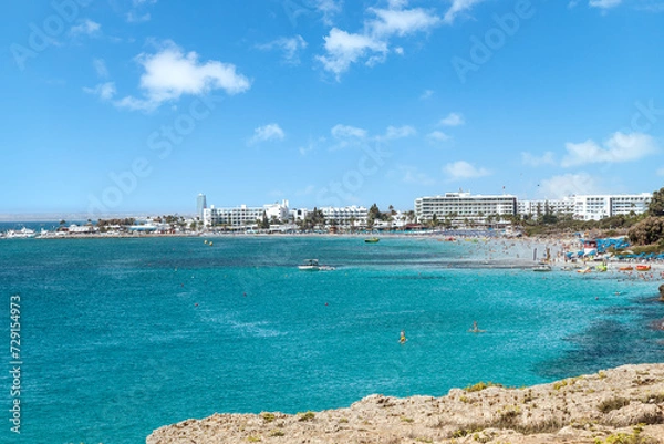 Fototapeta Vacation resort of Ayia Napa. A paradise for vacationers. A sunny day with a blue sky and white clouds. Panoramic view of the hotels and Nissi beach.